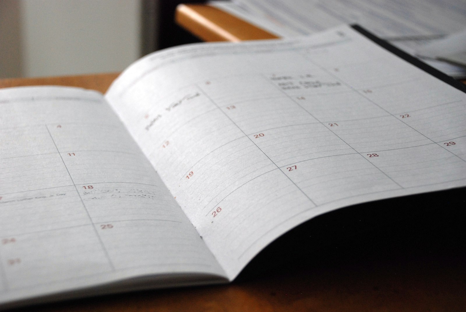 Agenda mensal aberta sobre uma mesa de madeira